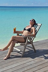 Image showing Beautiful young woman with a drink by the sea