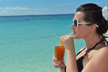 Image showing Beautiful young woman with a drink by the sea