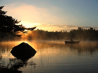 Image showing Rowing boat in a lake at sunrise.