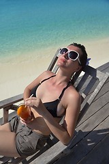 Image showing Beautiful young woman with a drink by the sea