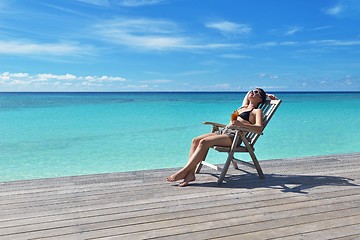 Image showing Beautiful young woman with a drink by the sea