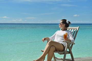 Image showing Beautiful young woman with a drink by the sea