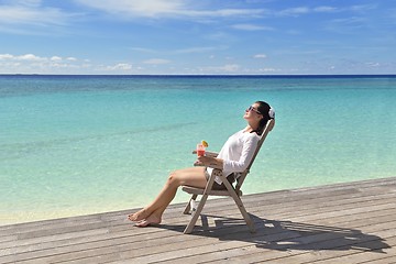 Image showing Beautiful young woman with a drink by the sea