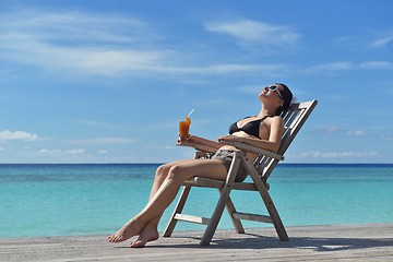 Image showing Beautiful young woman with a drink by the sea