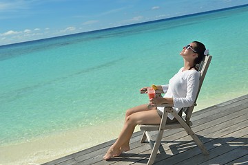 Image showing Beautiful young woman with a drink by the sea