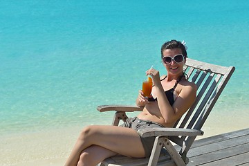 Image showing Beautiful young woman with a drink by the sea