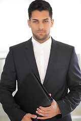 Image showing Serious young businessman with a folder