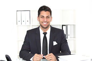 Image showing Handsome smiling businessman at his desk