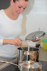 Image showing Smiling housewife cooking in the kitchen