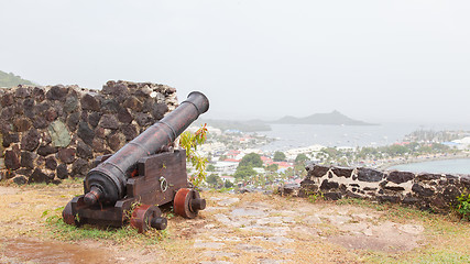 Image showing Very old rusted canon pointing at a bay