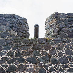 Image showing Very old rusted canon on top of an old wall