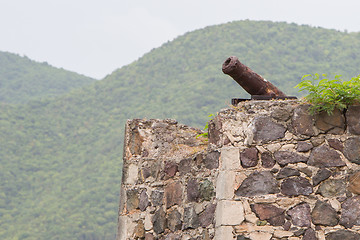 Image showing Very old rusted canon on top of an old wall