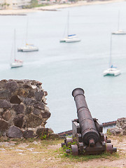 Image showing Very old rusted canon pointing at a bay