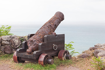 Image showing Very old rusted canon pointing at a bay