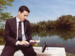 Image showing businessman using laptop outdoors b