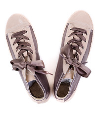 Image showing pair of fashionable sneakers on a white background. View from ab