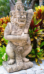 Image showing Thai stone god in the bushes of tropical plants