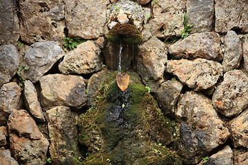 Image showing Small fountain in a rock wall