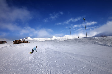 Image showing Hotel in winter mountains and snowboarder on slope