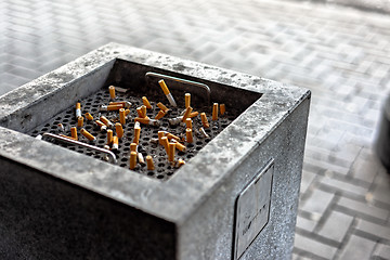 Image showing Cigarettes in a public ashtray