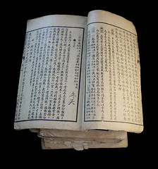 Image showing old open Chinese book on top of a stack