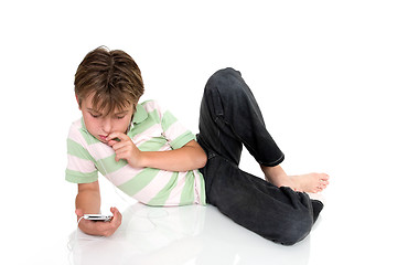 Image showing Child relaxing with an electronic gadget