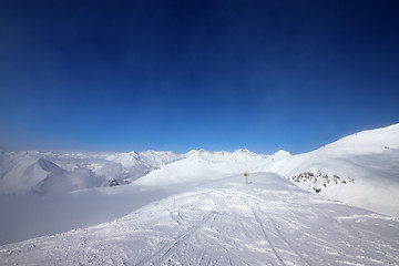 Image showing Warning sing on ski slope and snowy mountains in haze