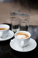 Image showing Two cups of coffee and water