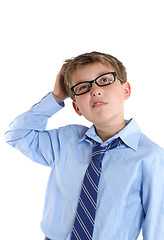 Image showing Schoolboy scratching head while thinking and looking up