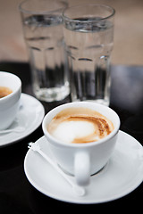 Image showing Two cups of coffee and water