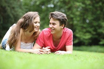 Image showing Teenage boy and girl lying on the grass