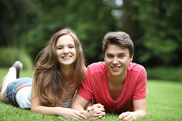 Image showing Attractive young couple lying on the grass