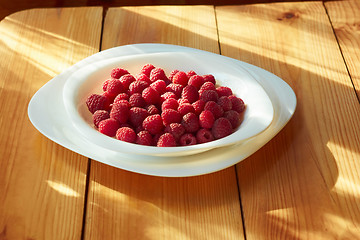 Image showing Raspberries in plate on the wooden table