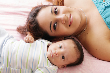 Image showing Portrait of happy young attractive hispanic mother lying with he