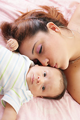 Image showing Hispanic woman kissing newborn 