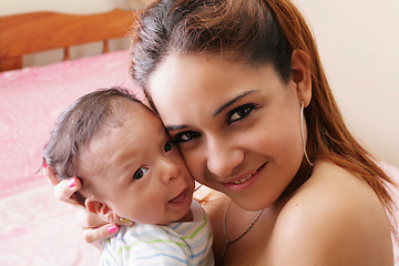 Image showing Portrait of a hispanic happy young mother holding a baby 