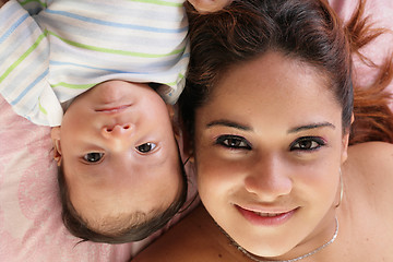 Image showing Portrait of a beautiful hispanic happy mother with baby lying do