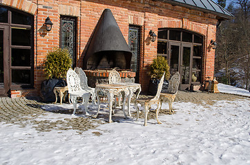 Image showing outdoor table chairs restaurant fireplace snow 