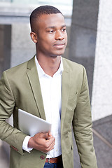 Image showing smiling successful businessman with tablet pc outdoor