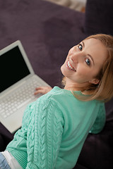 Image showing smiling woman on couch with notebook