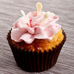 Image showing tasty sweet homemade cupcakes with cream on table