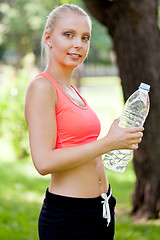 Image showing attractive young blonde woman drinking water outdoor sport