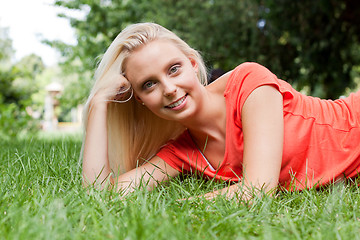 Image showing beautiful young blonde girl lying in grass summertime