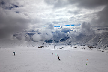 Image showing Skiers on ski slope before storm