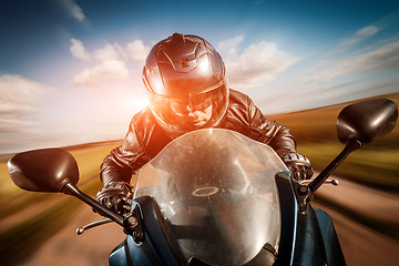 Image showing Biker racing on the road