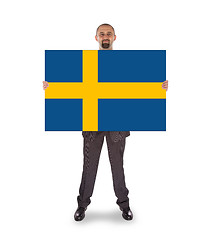 Image showing Smiling businessman holding a big card, flag of Sweden