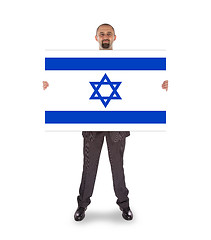 Image showing Smiling businessman holding a big card, flag of Israel