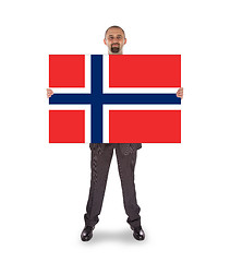 Image showing Smiling businessman holding a big card, flag of Norway