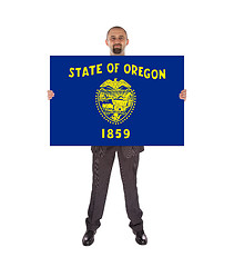 Image showing Smiling businessman holding a big card, flag of Oregon