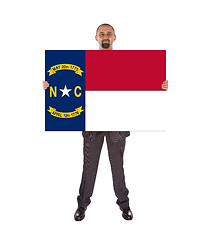 Image showing Smiling businessman holding a big card, flag of North Carolina